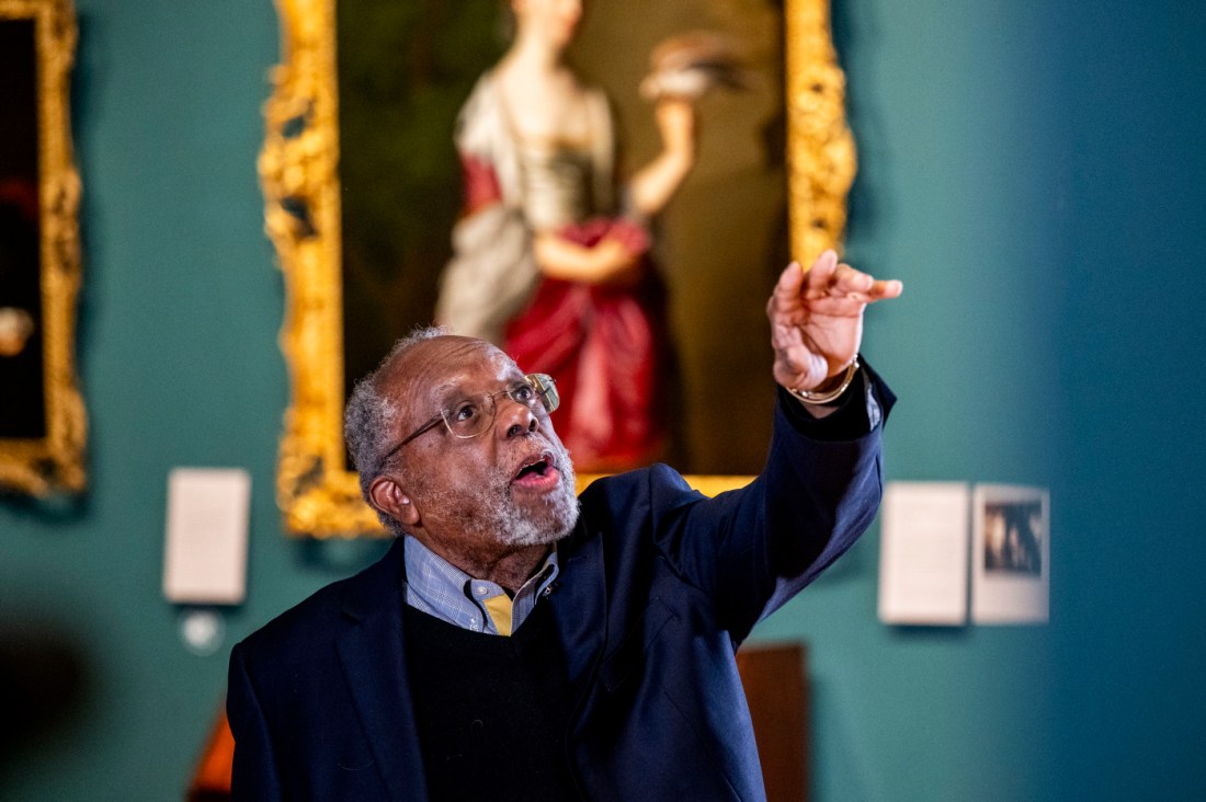 Ted Landsmark gestures upward while posing beside the painting “Watson and the Shark” at the Museum of Fine Arts in Boston.
