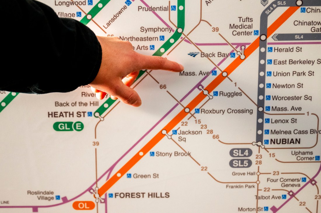 A closeup of Ed Lopas pointing at the Mass. Ave orange line stop on a T map.