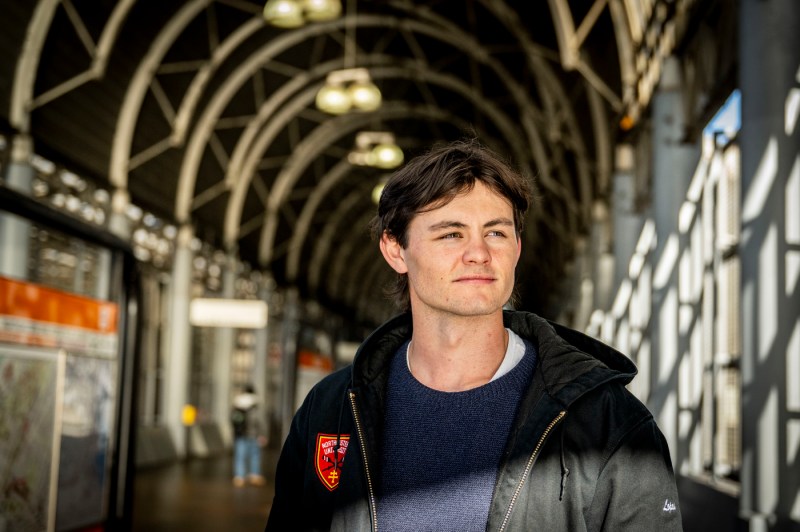 A portrait of a person dressed in black standing in Ruggles Station.