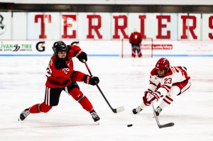 A Northeastern hockey player takes a shot on net at the Beanpot game.