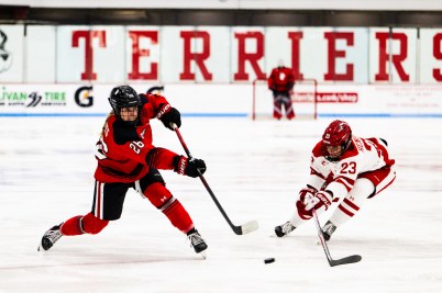 A Northeastern hockey player takes a shot on net at the Beanpot game.