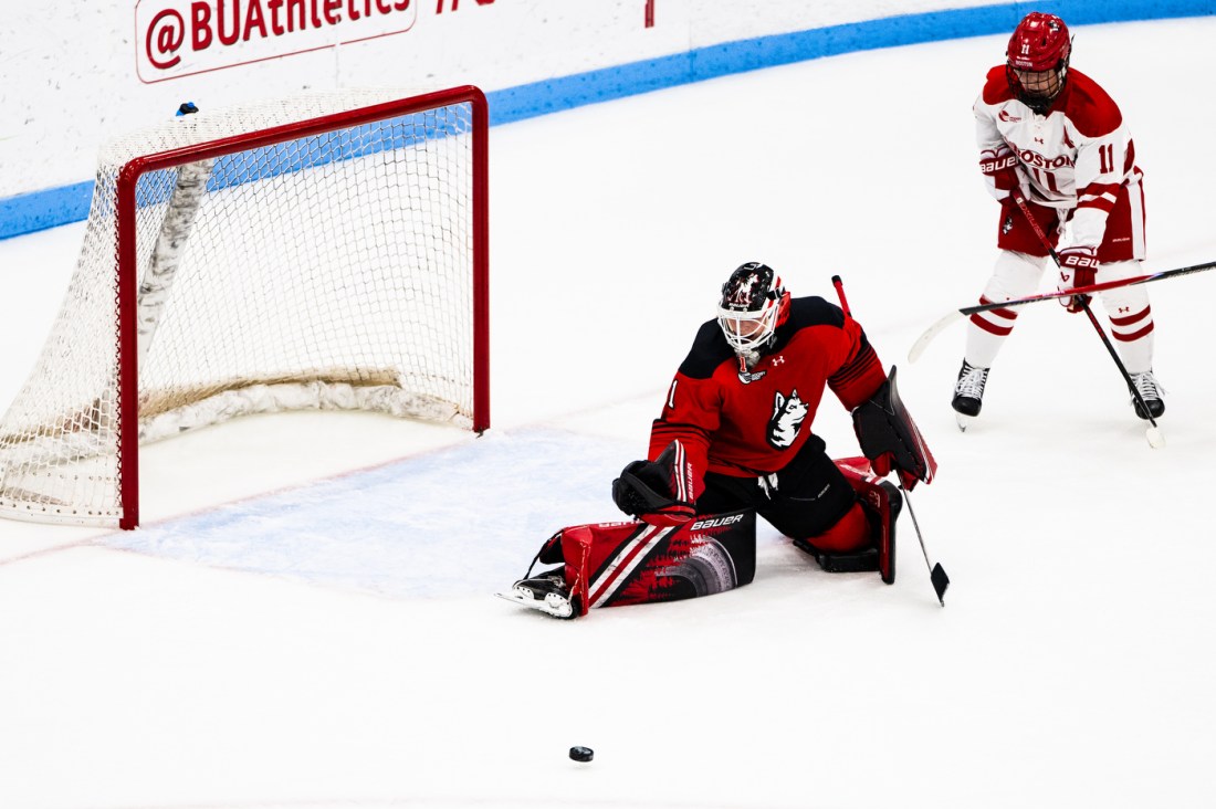 The Northeastern women's goalie attempts to save a shot on net.