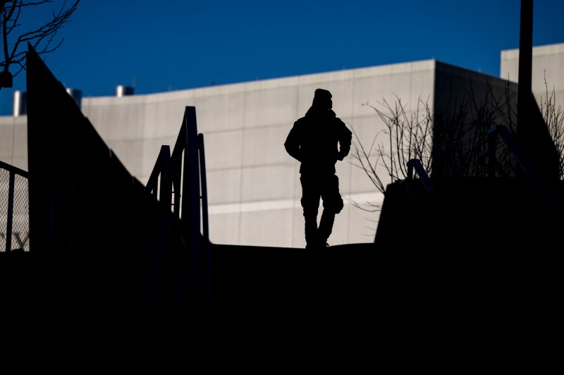 A silhouette of a pedestrian walking through campus.