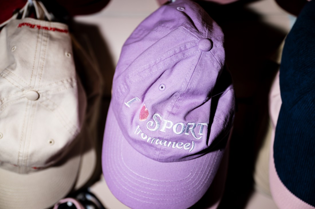 A closeup of a purple baseball cap that says I heart Sport (romance).