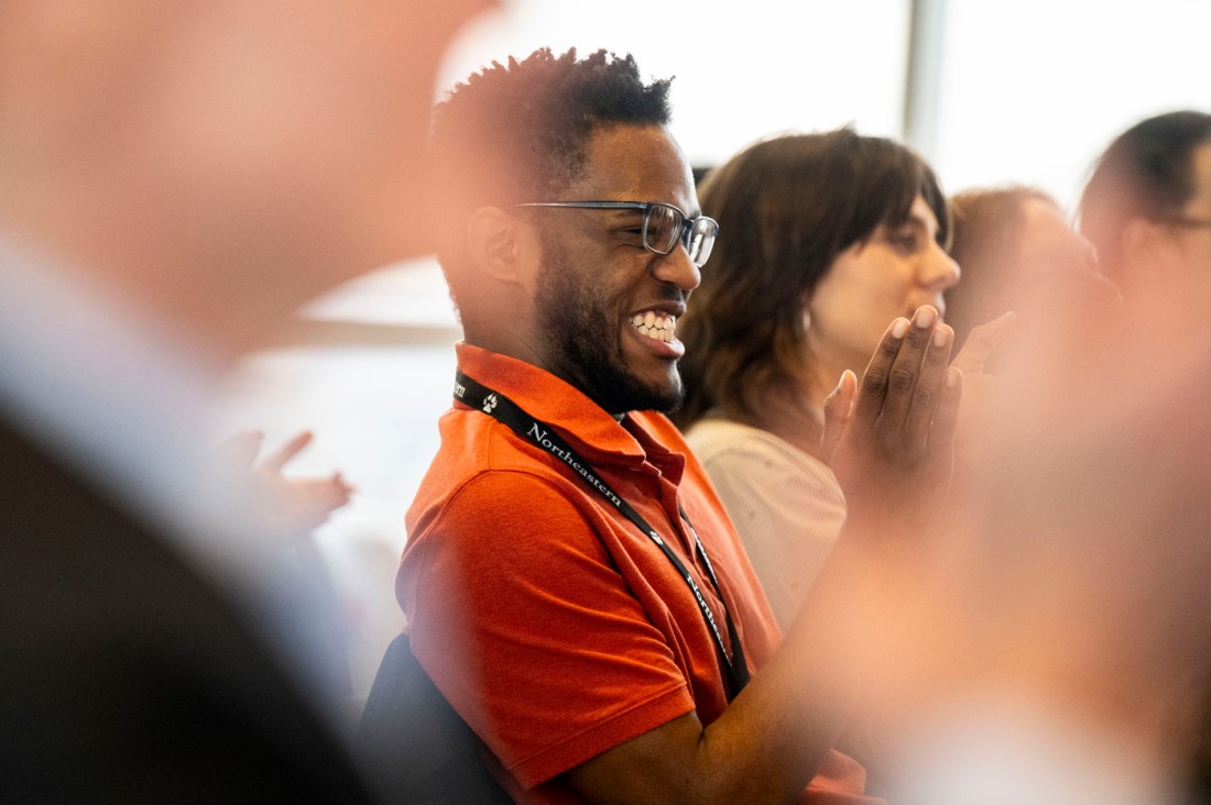 An audience member smiling and clapping. 