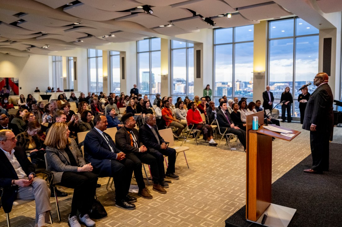 A singer giving a musical performance on stage in front of a crowd of audience members. 