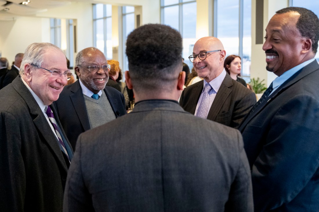 Zolan Kanno-Youngs, President Aoun, Richard O'Bryant, Ted Landsmark and others stand in a circle talking. 