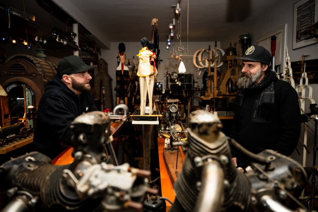 Michael Ulman and his brother, Jonathan Ulman, talk with each other while standing on opposite sides of a display of Michael Ulman's sculptures.