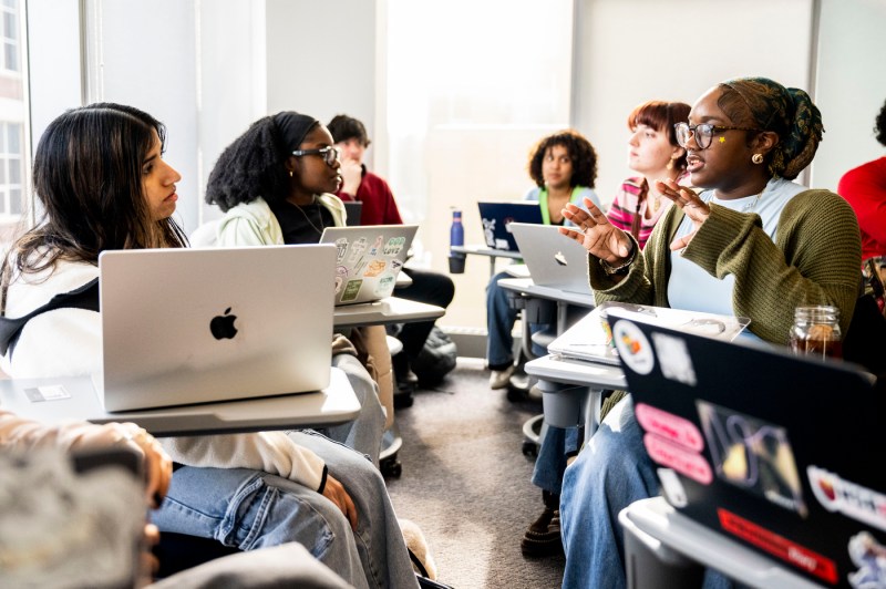 A classroom of students discusses with each other during a lesson.