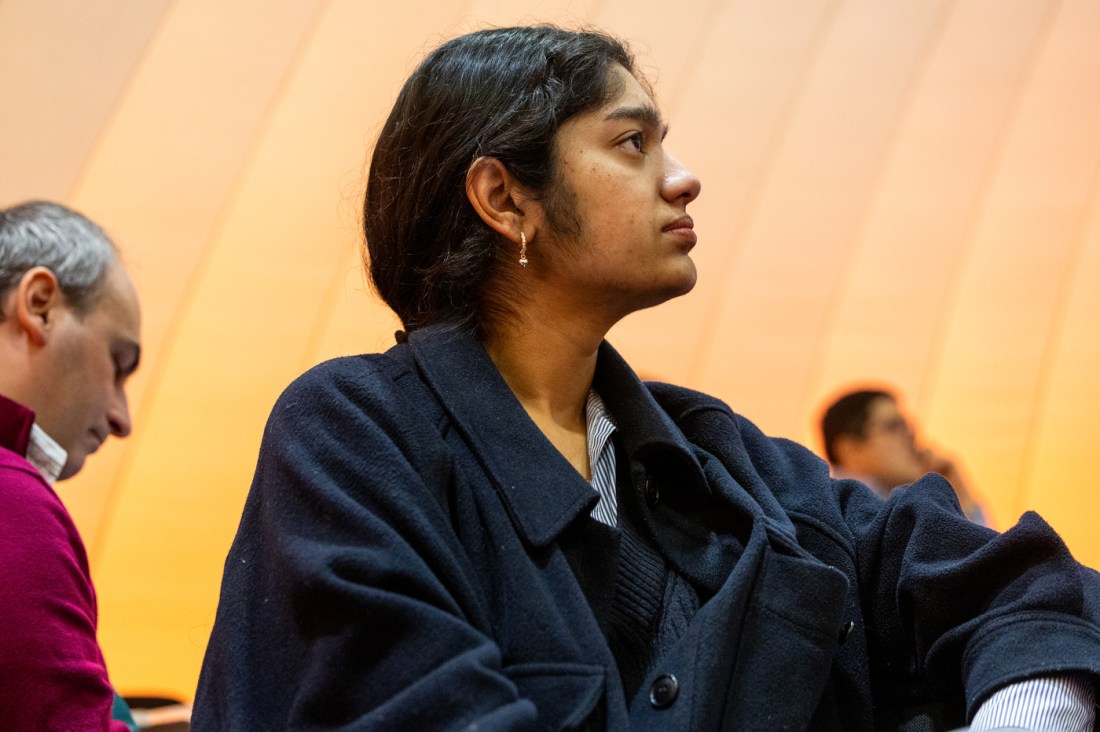 Woman with dark hair listening to event discussion