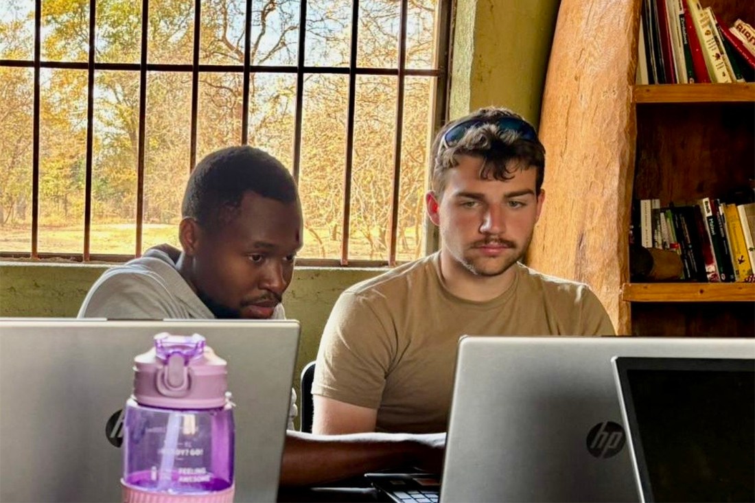 Northeastern student Ryan Sewell works on laptops with Lilongwe Wildlife Trust research team member.