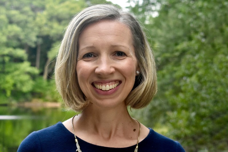 Woman in blue top and blonde hair smiling