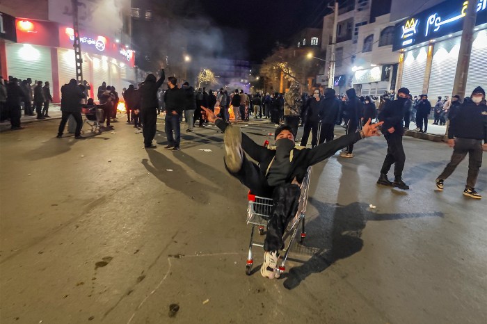 Iranians gather while blocking a street during a protest in Kermanshah, Iran.