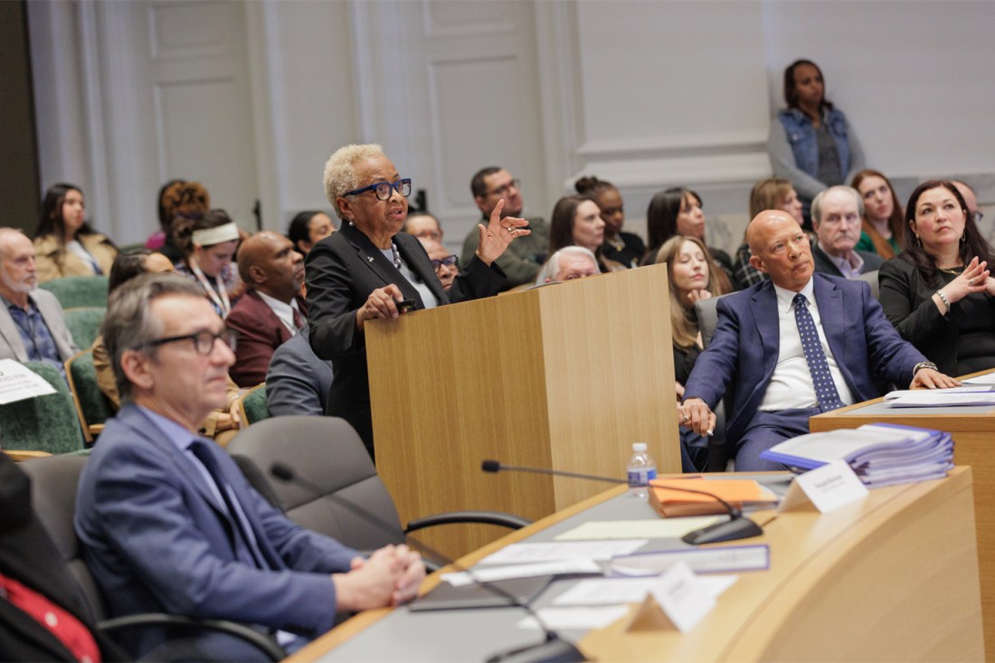 Dr. Margaret Burnham standing at a podium at a posthumous hearing speaking into a microphone.