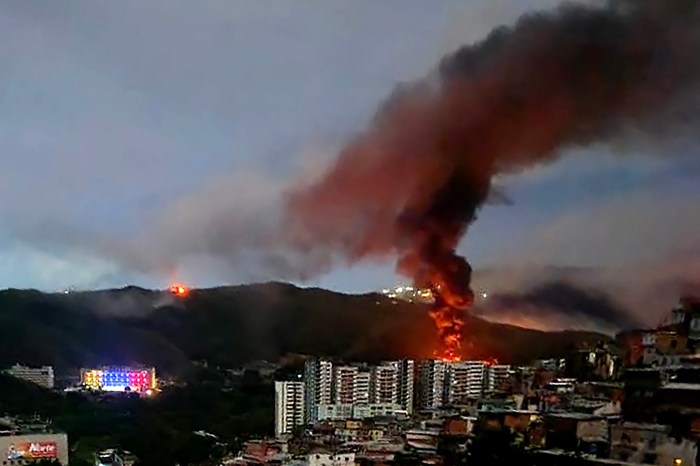 A fire billows in the early morning hours after a reported military strike in Venezuela.