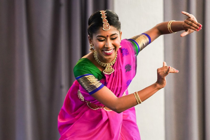 A dancer in traditional Indian attire of pink and green.