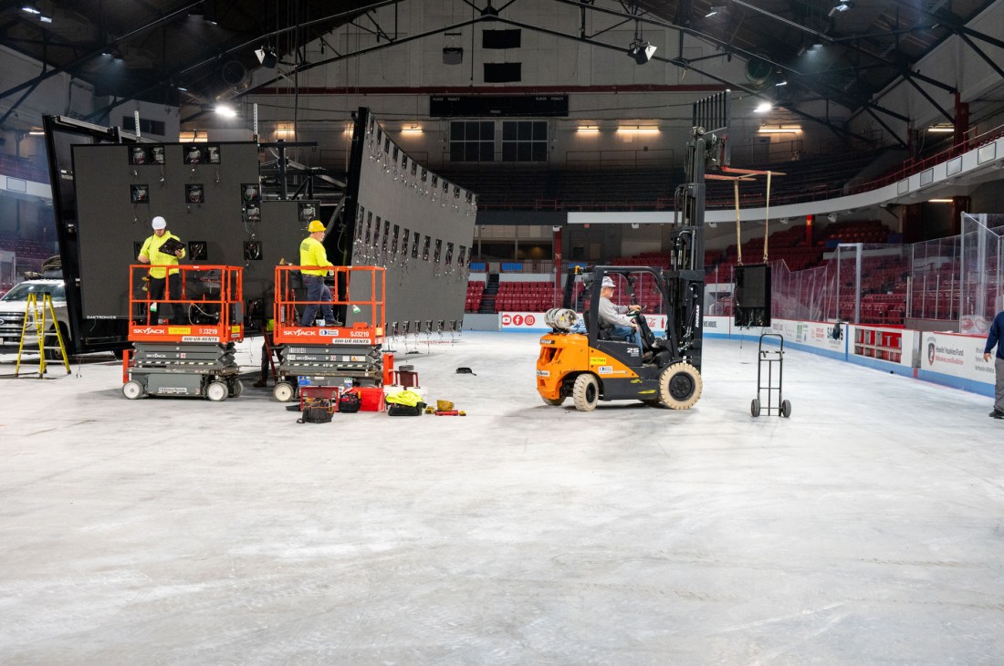 Workers in high vis yellow shirts and hard hats on orange risers working on deconstructing Matthews Arena from the inside.