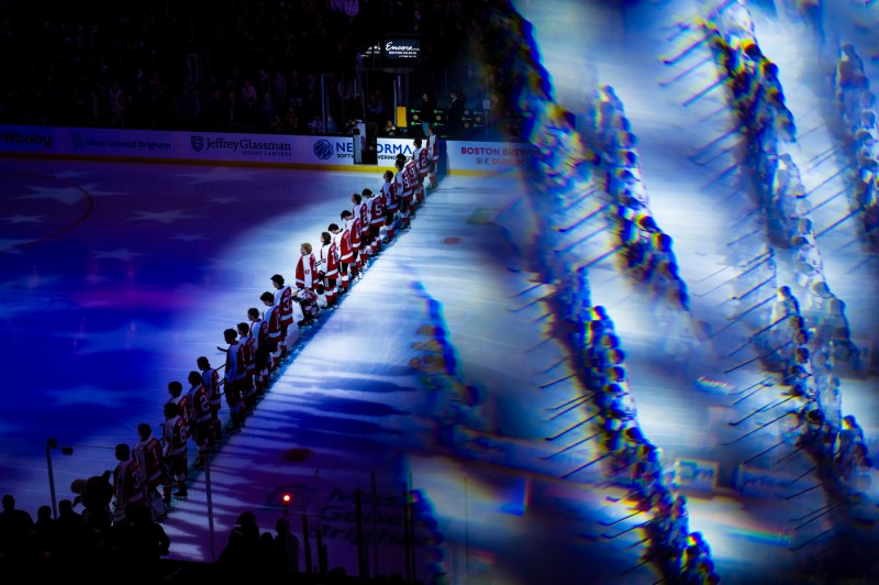 A lineup of the Northeastern hockey team with camera effects showing their multicolored reflection.