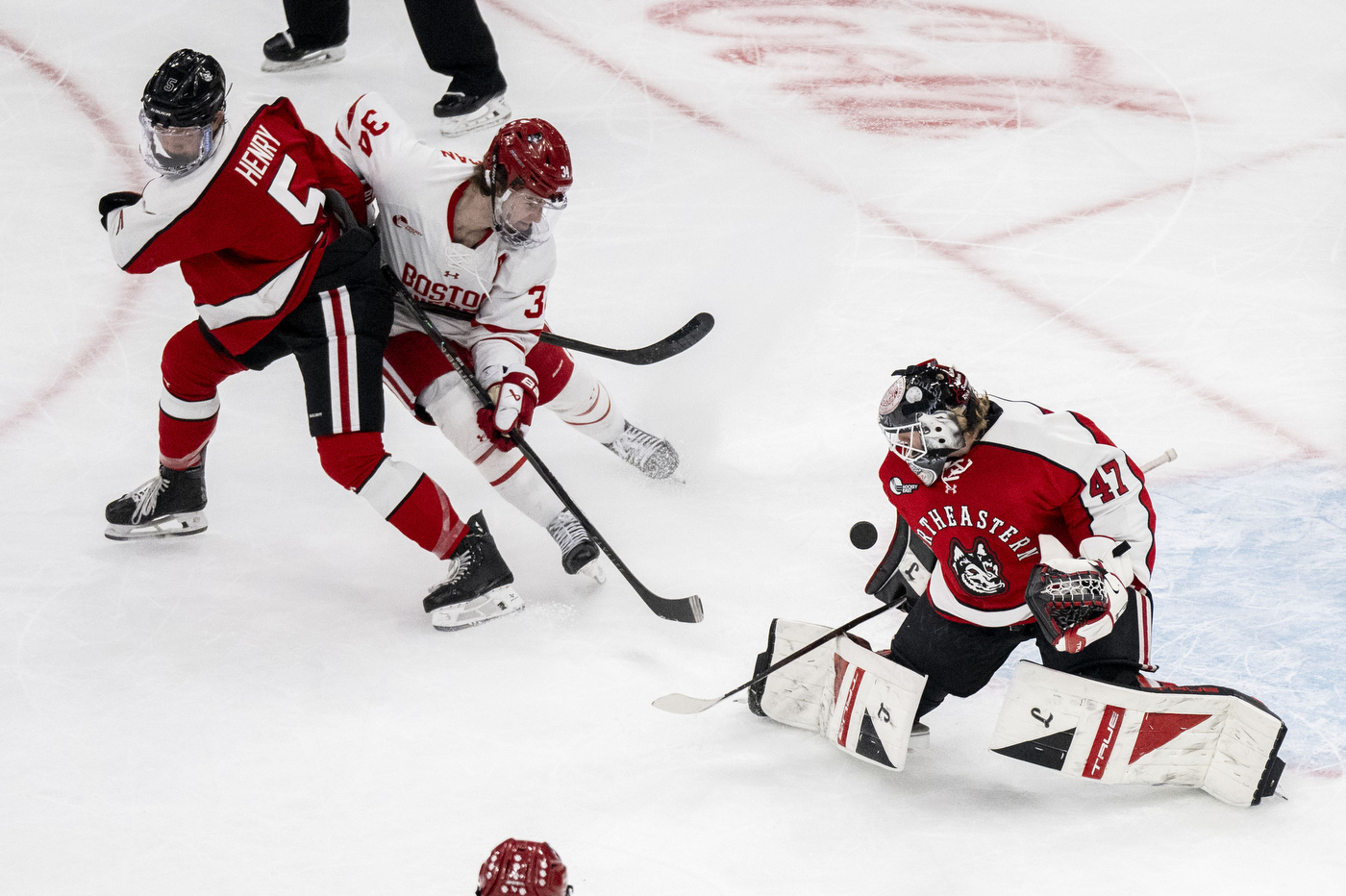 Northeastern and Boston University players collide near the crease as the BU goalie drops to the ice during a tense play in the Beanpot semifinal.