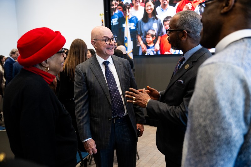 The university president shakes hands and mingles with other people.