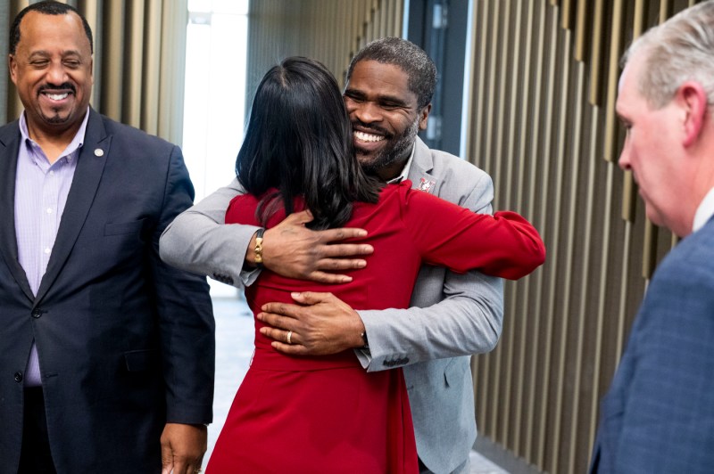 The mayor of Boston embraces a Northeastern staff member in a hug.