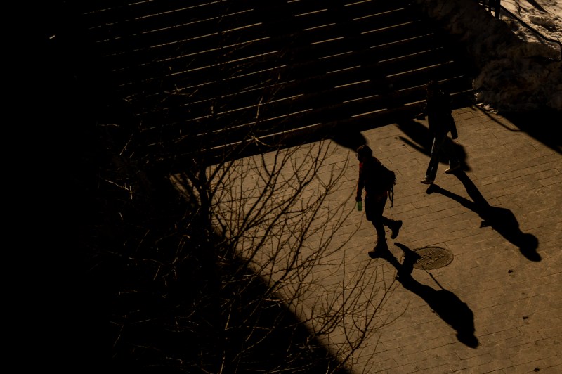 People walking through the Boston campus cast shadows.