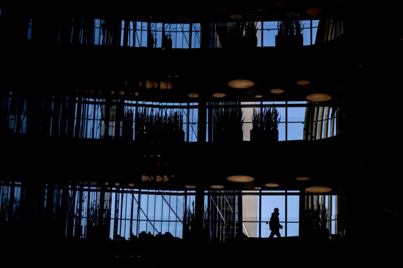 A silhouette of a student walking through ISEC. Multiple floors of the building are pictured. 