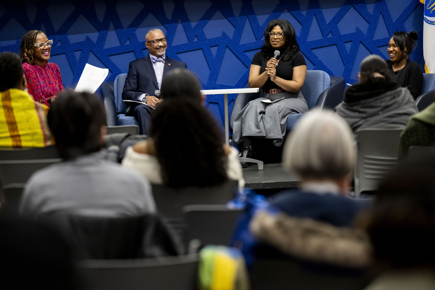 Four people sit on a stage during the "A Litany for Survival: Black Studies, Black Scholars, & Black Students" event. 