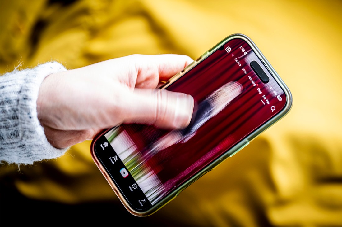 A hand holding a smartphone with a blurry screen.