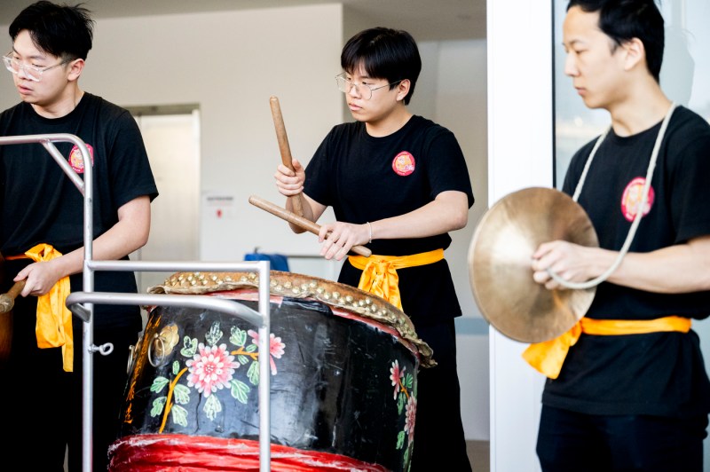 Three people perform using musical instruments. 
