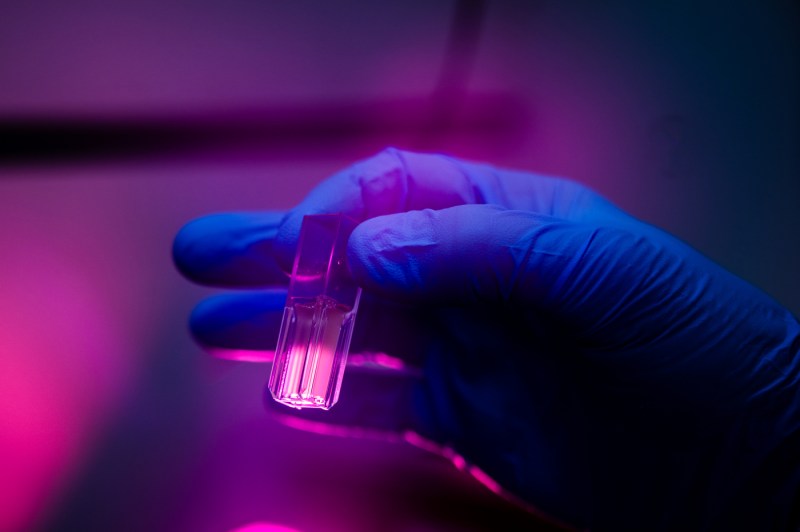 A person's hand holds a test tube.