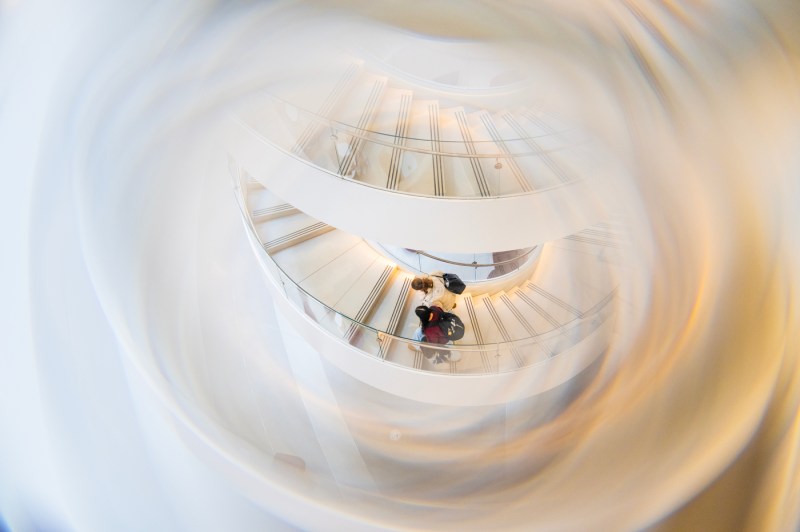 An aerial view looking down at a person on a spiral white staircase.
