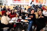 A group of students sit at a table for a watch party of the gold medal hockey game.