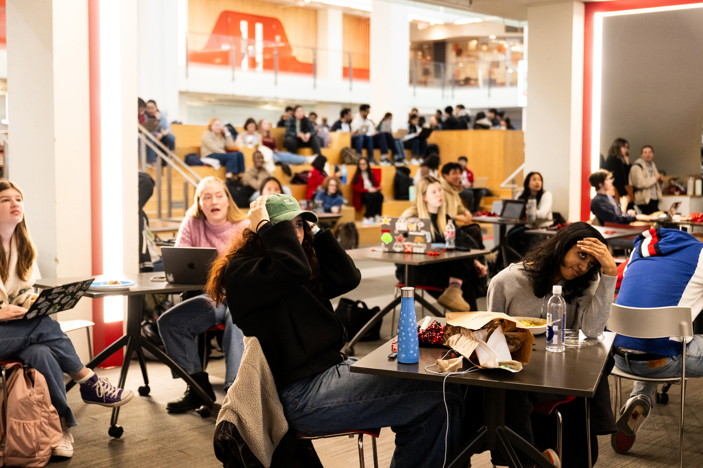 Students sit at tables in Curry Student Center watching the gold medal hockey game.