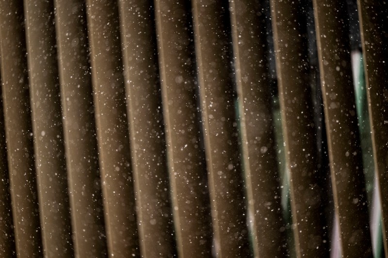 A close up of the exterior of a building while snow falls.