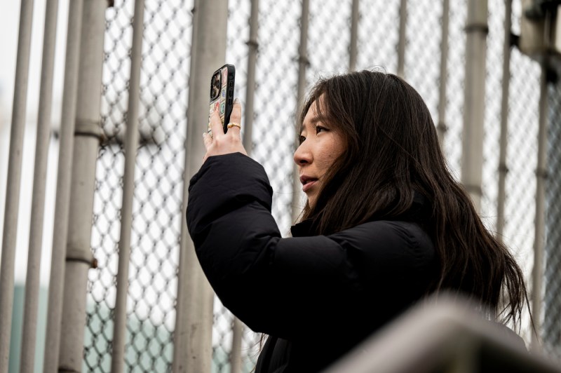 A close up of a person holding a cell phone and taking a photo.