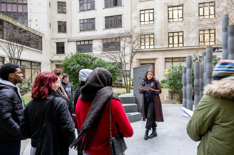 People take part in a walking tour guided by a woman