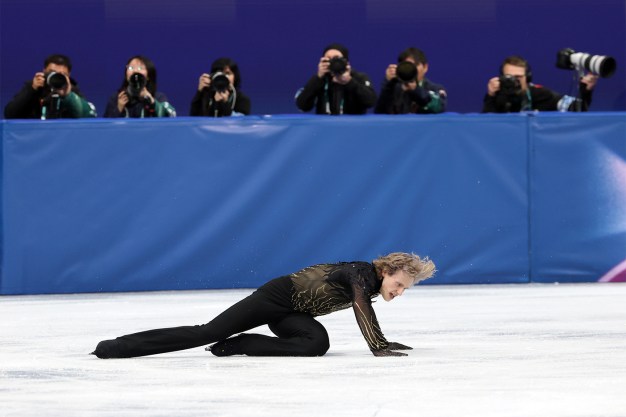 Ilia Malinin on the ice after falling over during a skating program at the Olympics.