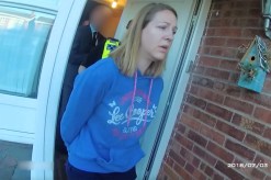 Woman wearing blue hooded jumper in police handcuffs