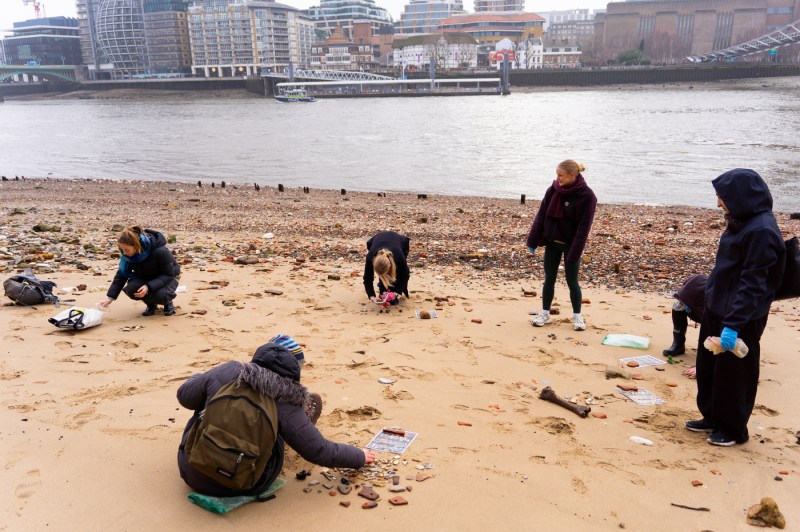 People collect items next to a river