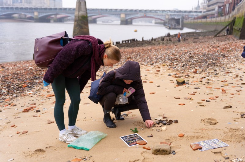 People collect items next to a river
