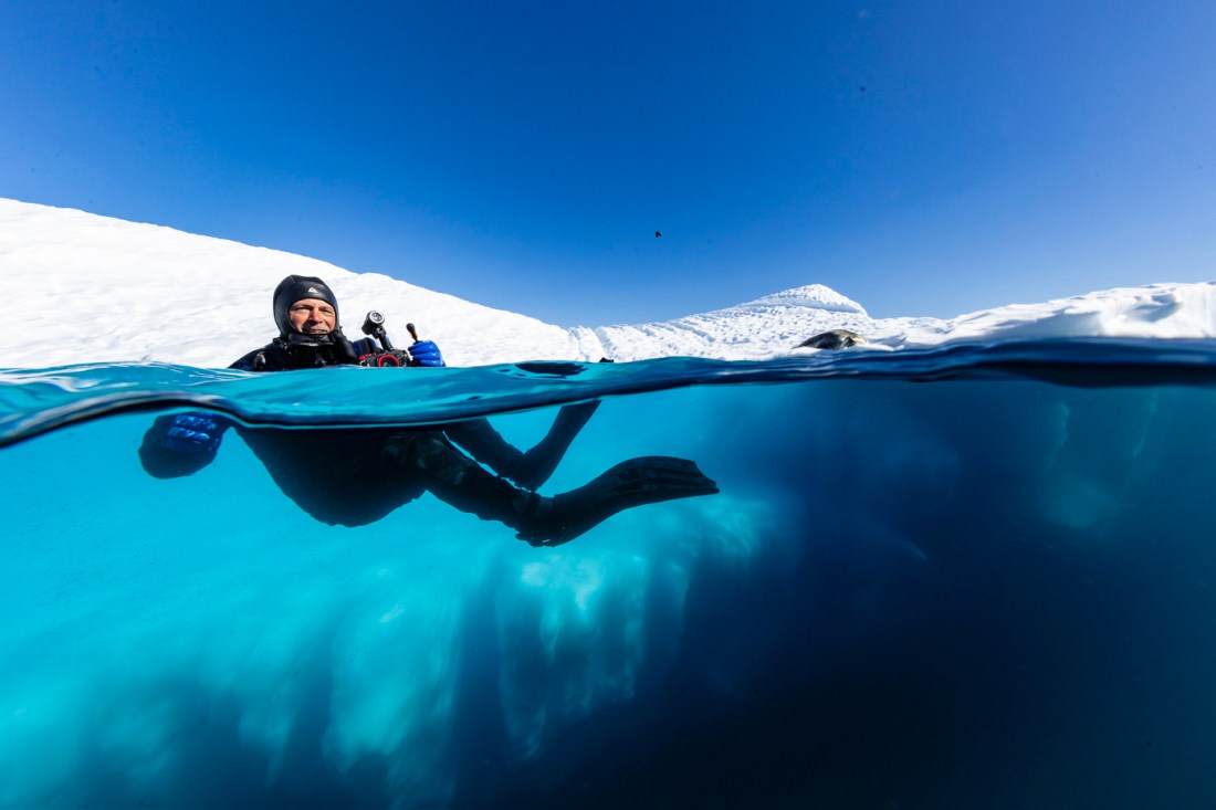 Richard Whalen, photographed from water level, seen in diving gear with most of his body underwater and his head above on a diving trip in Antarctica.