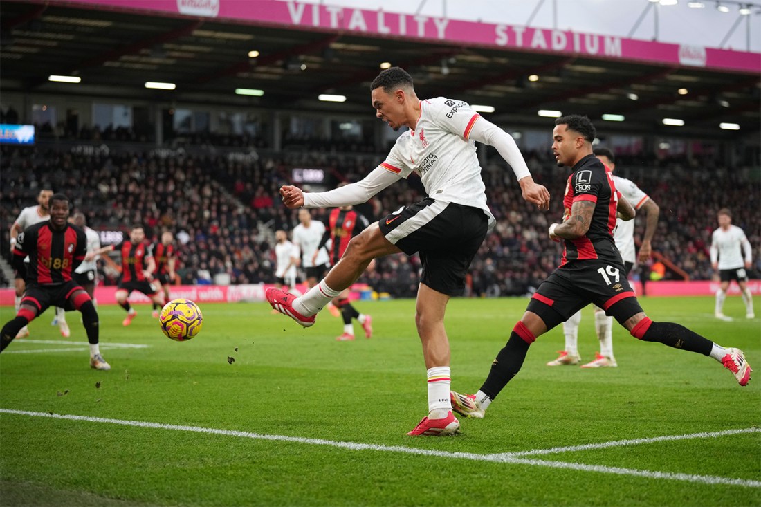 Trent Alexander-Arnold, a player for the Liverpool soccer team in Engalnd, kicking the ball on the pitch during a game.
