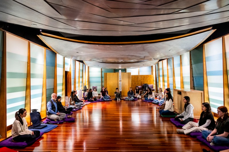 A group of students, faculty and staff sit and meditate in the Sacred Space at Northeastern University.