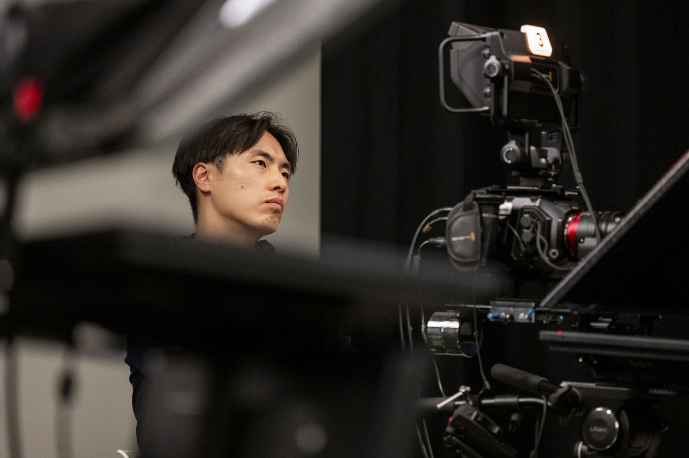 A camera operator monitors equipment during the taping of an NGN Podcast episode at Northeastern University.