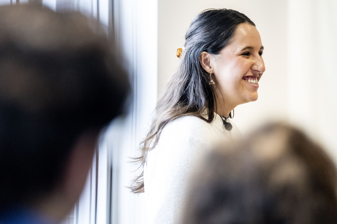 A student smiles at the audience during a Holocaust and Genocide Awareness presentation on her family history.