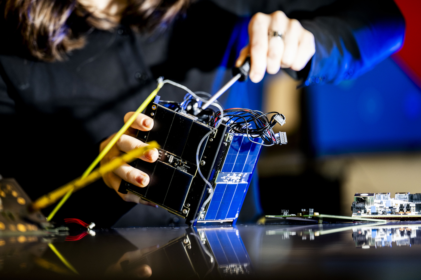 Laura Teixeira, a fourth-year mechanical engineering student and mechanical chief of the Satellite Laboratory, works on the  satellite prototype.   