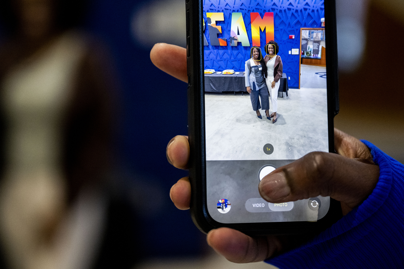 A person takes a photo with their iPhone at the event.