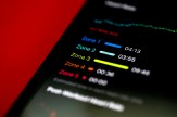A smartphone displaying information about heart rate zones against a red backdrop.