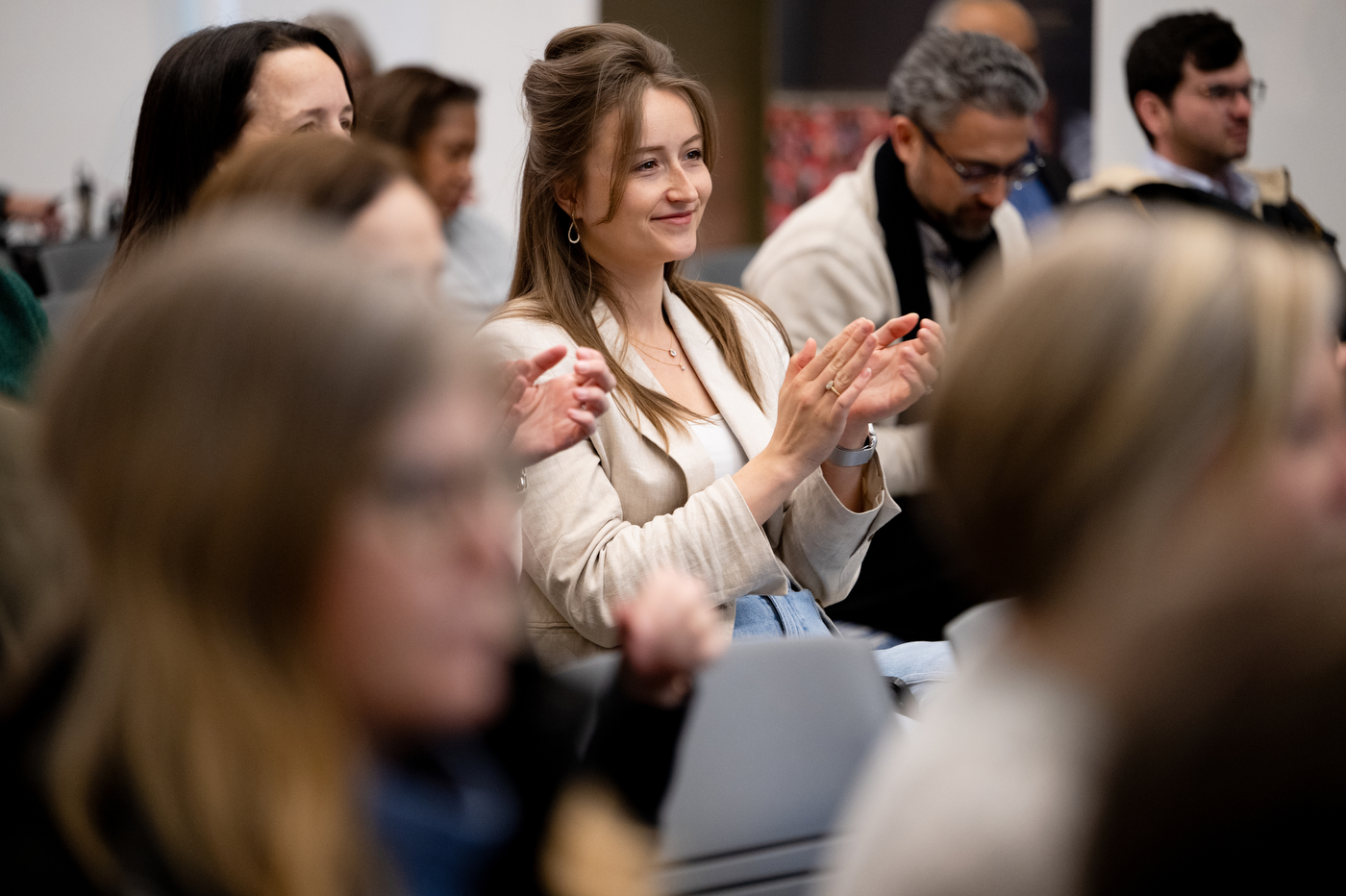 People in the audience clap their hands and smile.